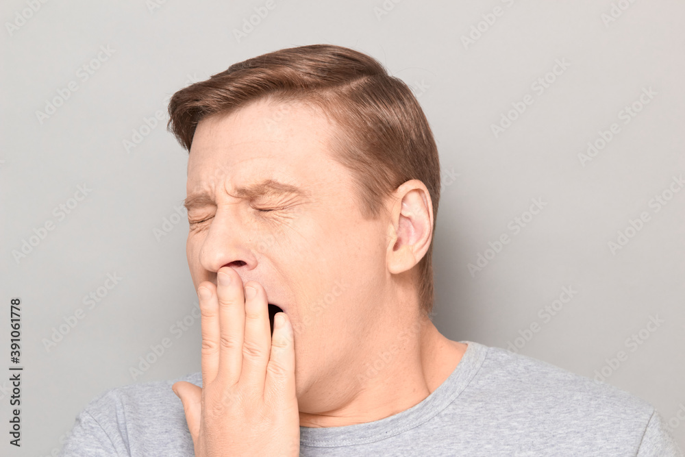 Portrait of sleepy man yawning at large and covering mouth with hand Portrait of sleepy man yawning at large and covering mouth with hand