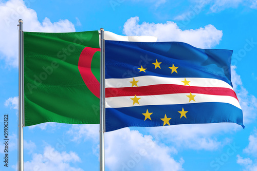 Cape Verde and Algeria national flag waving in the windy deep blue sky. Diplomacy and international relations concept.