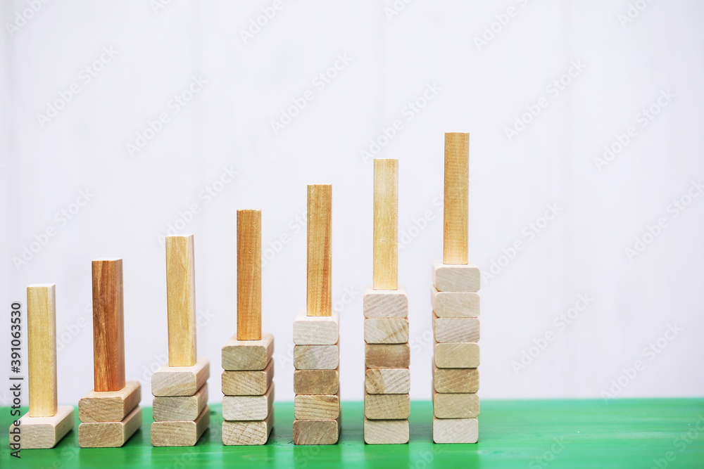 Stick wood block standing on stacked square wood blocks, abstract background in concept of winning, success, challenge, step to top position.