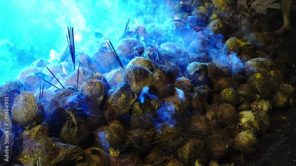 Pile of coconut with incense stick and smoke release with LED light at background.