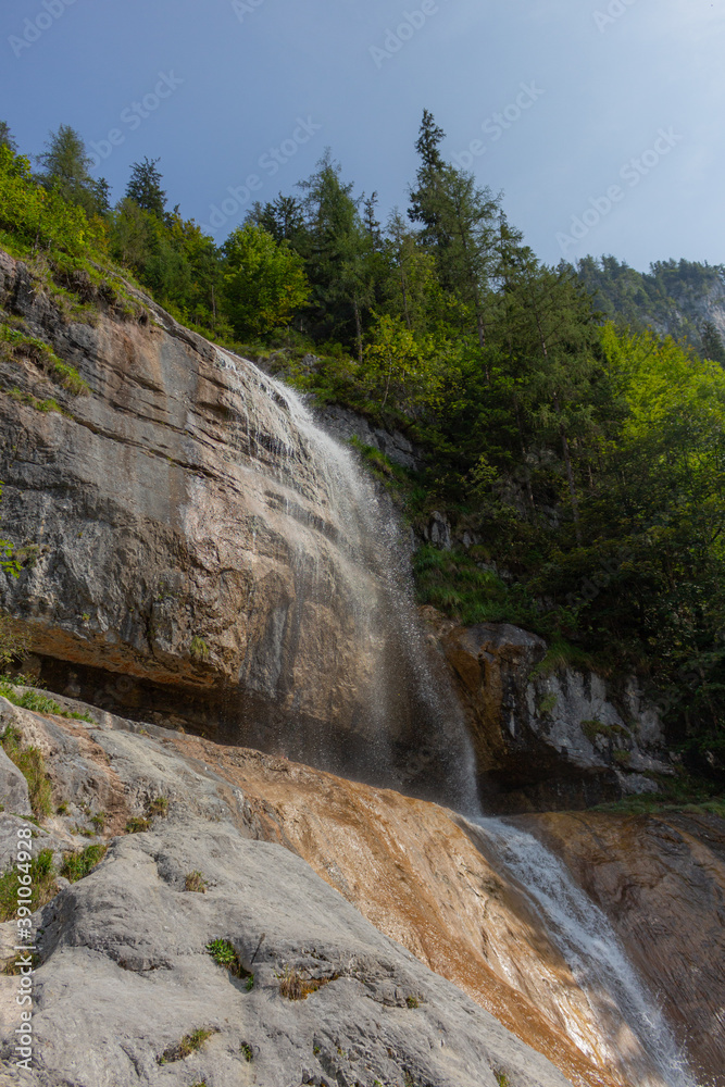 Berchtesgaden waterfall under the cliffs on a summer day at lake Königssee