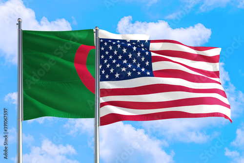 United States and Algeria national flag waving in the windy deep blue sky. Diplomacy and international relations concept.