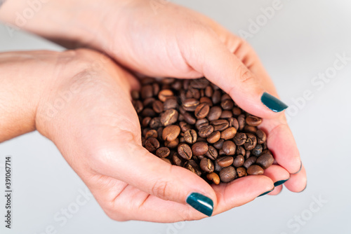 Coffee grains in woman hand.