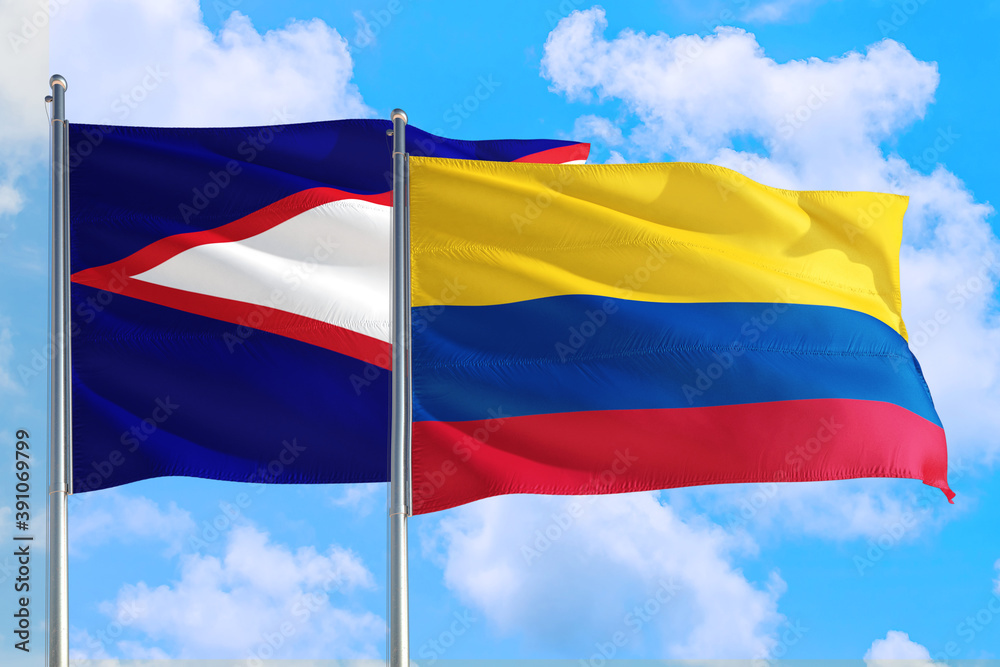 Colombia and American Samoa national flag waving in the windy deep blue sky. Diplomacy and international relations concept. Colombia and American Samoa national flag waving in the windy deep blue sky. Diplomacy and international relations concept.