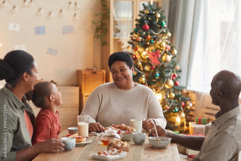 Warm toned portrait of big African-American family enjoying tea and snacks while celebrating Christmas at home Warm toned portrait of big African-American family enjoying tea and snacks while celebrating Christmas at home