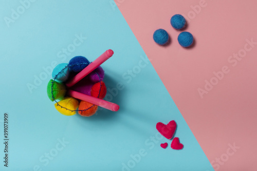Flat lay of felt multicolored pencil stand on pink and blue background
