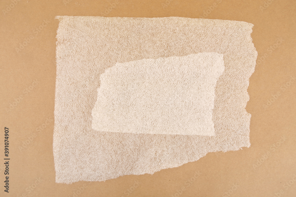 Obraz premium White plastic foam sheet pieces on cardboard background. Closeup of torn foam polyethylene pieces.