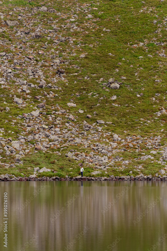 Alpine lake Brebeneskul, the cradle of the Carpathians, a couple of tourists near the lake, reflection in the water. Alpine lake Brebeneskul, the cradle of the Carpathians, a couple of tourists near the lake, reflection in the water.