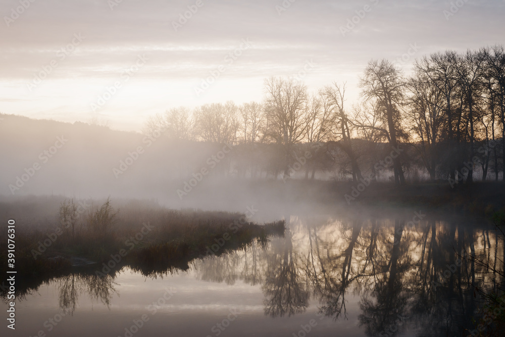 Autumn landscape fog over river and sky with rising sun