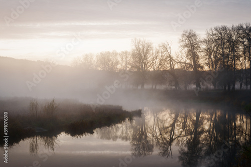 Fototapeta Naklejka Na Ścianę i Meble -  Autumn landscape fog over river and sky with rising sun