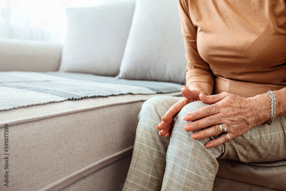 Elderly woman suffering from pain in knee at home, closeup. Health ...