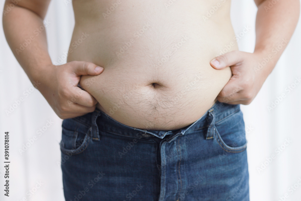 Naklejka premium Man with fat belly in dieting concept. Overweight man touching his fat belly and want to lose weight.