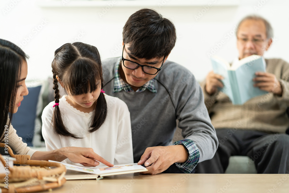 Fototapeta premium Daughter reading story with multigenerational family