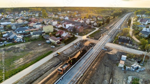 Aerial view on small village located in central Poland. Summer landscape, cloudy afternoon. Green meadows, calm light. Railroad under construction.