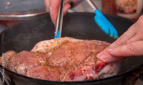 Fresh raw pork steak with spices roasting on frying pan photo