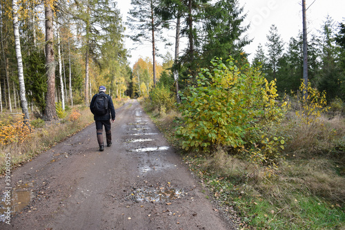 Hiker on a dirt road in fall season © Birgitta