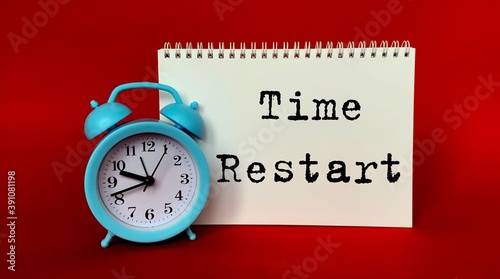 Write the restart time in White Notepad .Next to it is a blue clock on a red background.