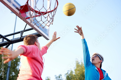 slam dunk. young caucasian basketball players, boys throwing ball into basketball hoop at playground. summer days, holidays © alfa27