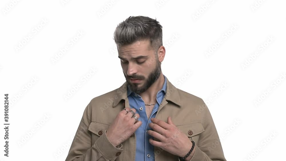 cool young man in casual outfit checking clothes, pointing fingers and making chef's gesture, shrugging and standing isolated on white background in studio cool young man in casual outfit checking clothes, pointing fingers and making chef's gesture, shrugging and standing isolated on white background in studio