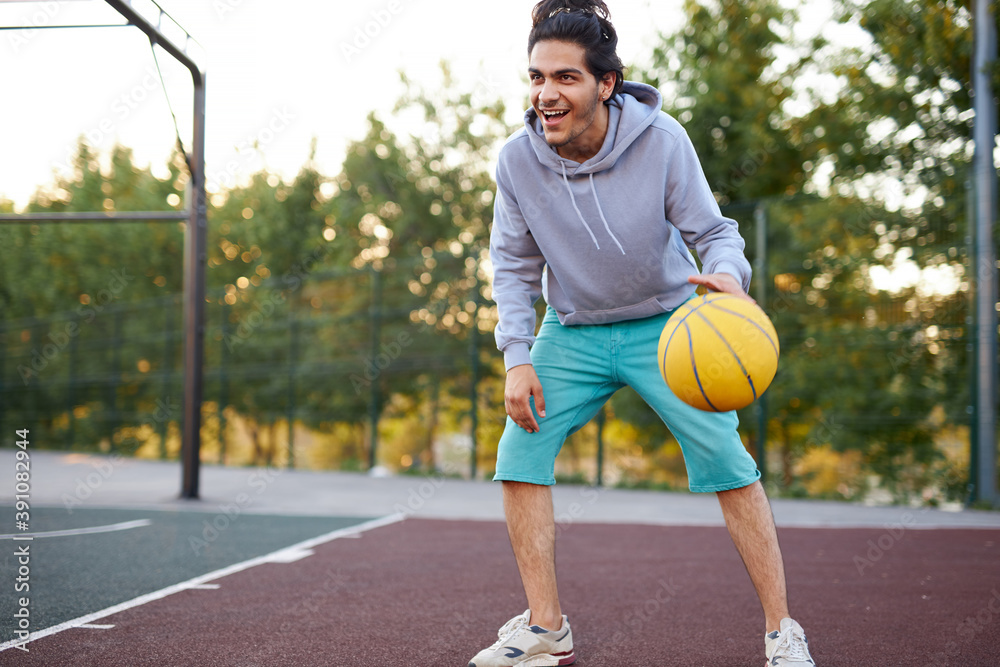 athletic young boy in casual wear keen on basketball, enjoy playing outdoors, sport concept