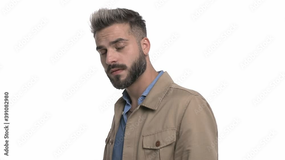 side view of young man looking behind, searching and shrugging in a confused manner, standing isolated on white background in studio side view of young man looking behind, searching and shrugging in a confused manner, standing isolated on white background in studio