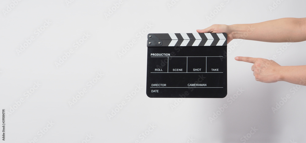 A man hand is holding black Clapper board or movie slate. it use in video production or cinema industry.It is white background.