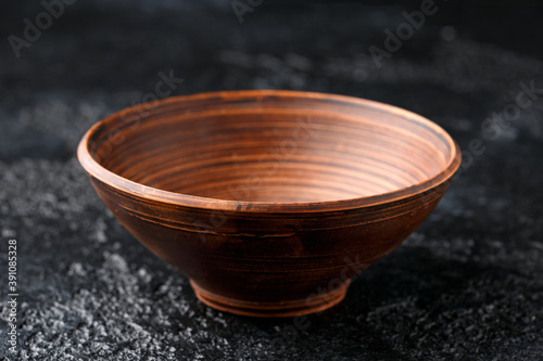 rustic handmade brown clay bowl plate on black background