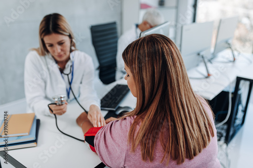 Doctor cardiologist measuring blood pressure of her diabetic patient. Healthcare concept.