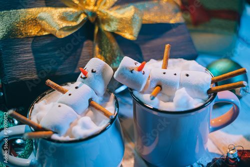 Obraz na płótnie a mug with hot chocolate on a wooden table with a marshmallow man who is resting in a mug w salonie
