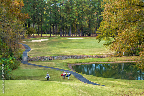 Golfers walking on a golf course photo