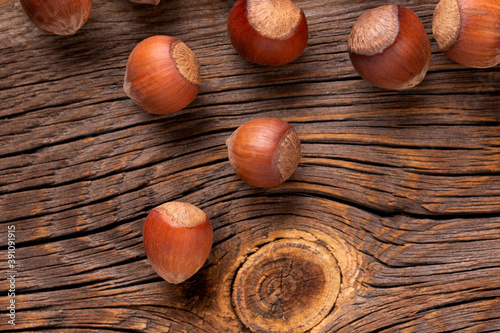 Hazelnuts on a wooden background. Scattered nut in shell. Hazelnuts in shells on a wooden background top view. 