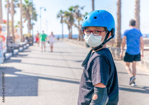 Close up portrait of boy with protective face mask riding on roller skates