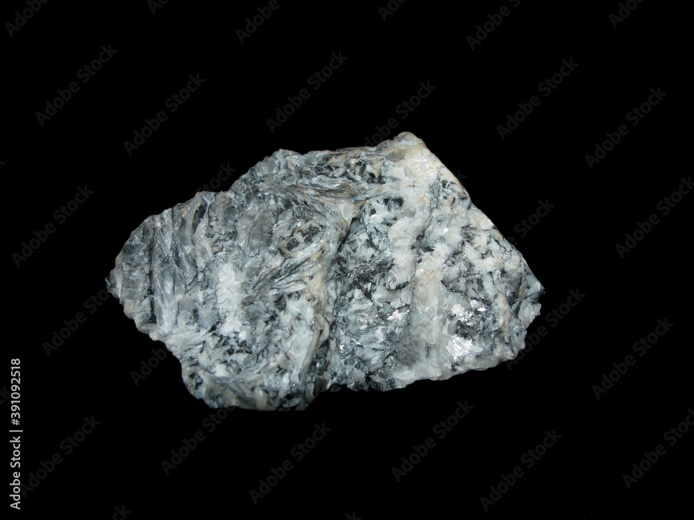 Sample of raw white with black inclusions of magnesite on a black background Sample of raw white with black inclusions of magnesite on a black background