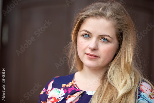 Portrait of a blonde girl with blue eyes. A girl with a European style face.
