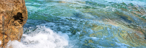 splash of sea water waves near big brown rock on coast aerial view