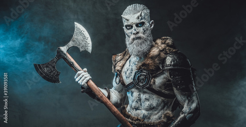 Mystery and evil fashion of northern king of the dead with white skin and hairs holding two handed huge axe in smokey background.