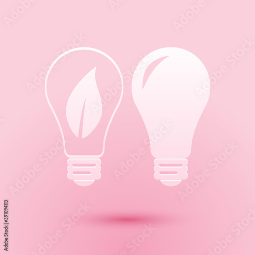 Paper cut Classic Lamp and Light bulb with leaf inside icon isolated on pink background. Lighting electric lamp. Green eco energy concept. Paper art style. Vector. © mingirov