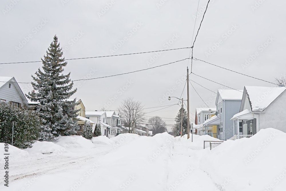 Typical canadian houses with big heaps of snow in front on a cold grey winter day in Gatineau, Quebec, Canada Typical canadian houses with big heaps of snow in front on a cold grey winter day in Gatineau, Quebec, Canada