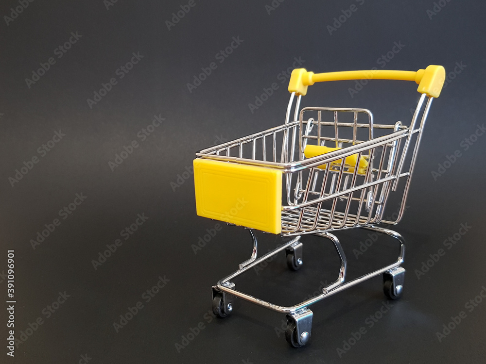Yellow toy cart on black isolated background