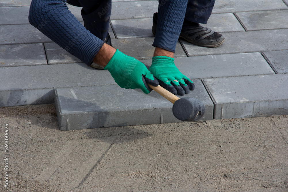 Brick Paver Working. Worker lay paving tiles, construction of brick pavement. Architecture background Brick Paver Working. Worker lay paving tiles, construction of brick pavement. Architecture background