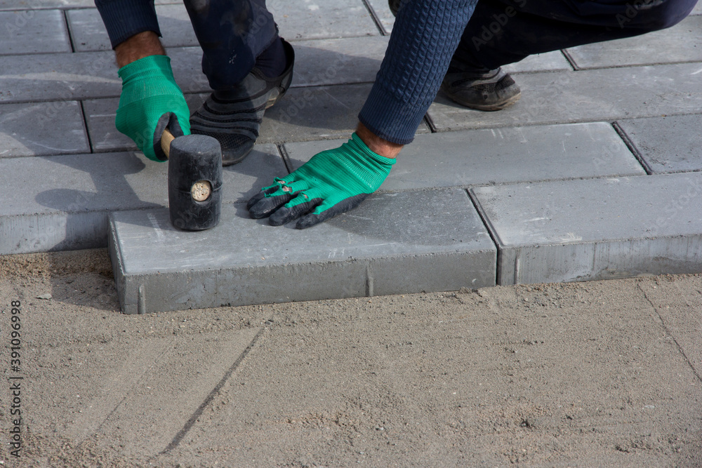 Brick Paver Working. Worker lay paving tiles, construction of brick pavement. Architecture background Brick Paver Working. Worker lay paving tiles, construction of brick pavement. Architecture background