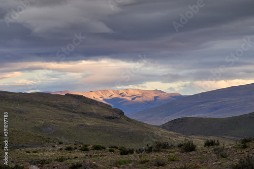 Moody sunset over the andean mountains of Torres del Paine national park with golden sunlight and dramatic clouds in the sky  Chile south America