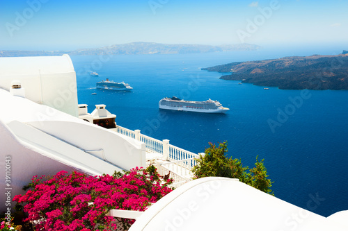 White architecture on Santorini island, Greece. Flowers on the terrace with sea view. Travel destinations concept