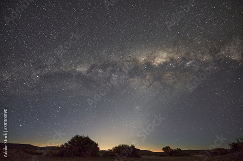Stary sky with milky way across the frame sunrise and mointains in the dark background in Argentina Patagonia south America 