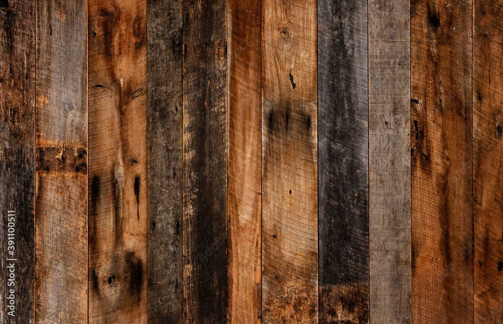 Dark stained reclaimed wood surface with aged boards lined up. Wooden