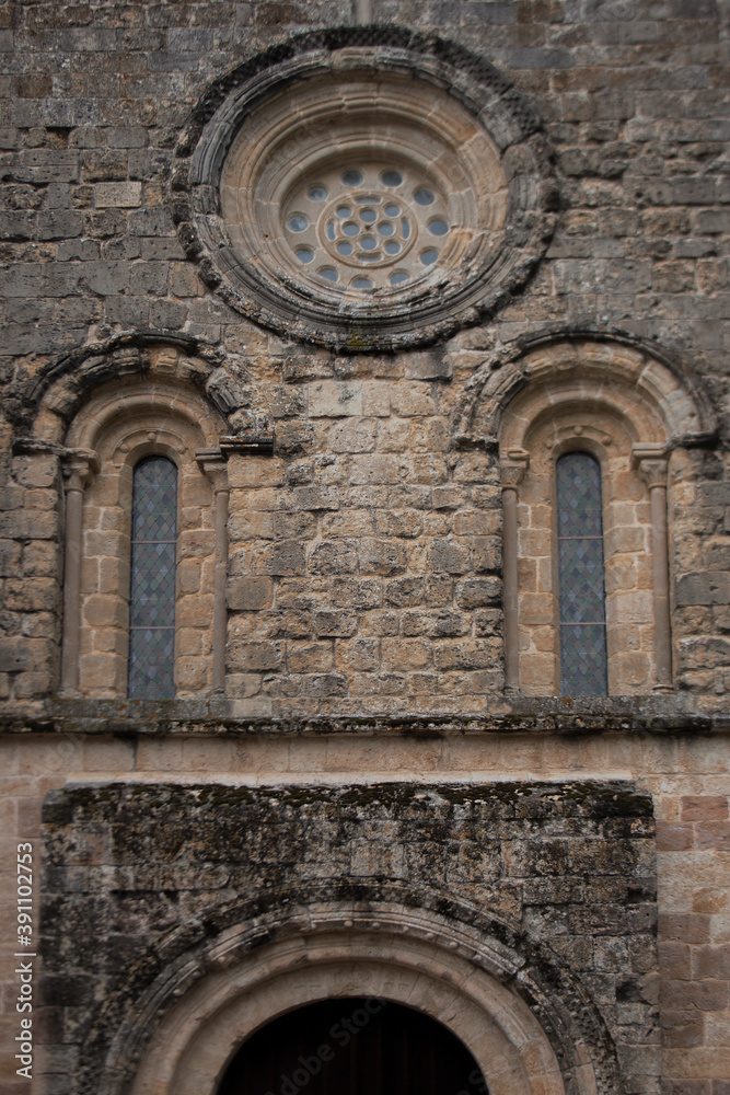 Obraz premium Front view of an entrance. Architectural details of an old stone traditional abbey. Arch windows from old stone.