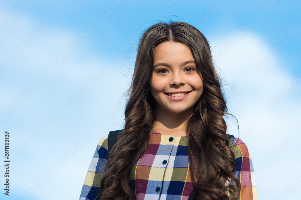 Share a new perfection. Happy child wear long wavy hairstyle outdoors. School look of little girl. Hair salon. Hairdressing education. Total haircare and scalp beauty solution Share a new perfection. Happy child wear long wavy hairstyle outdoors. School look of little girl. Hair salon. Hairdressing education. Total haircare and scalp beauty solution
