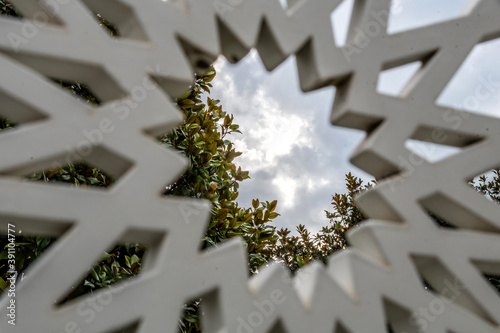 Vue sur un ciel nuageux au travers d'une sculpture dans le jardin du monastère de Cimiez à Nice photo