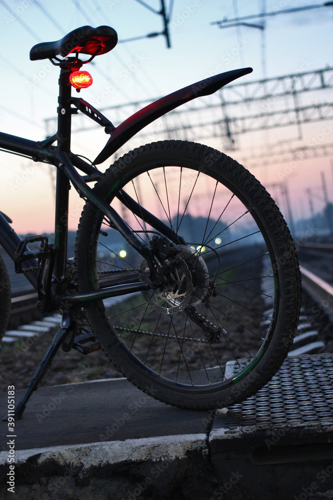 Fototapeta premium Bicycle on the railway track at sunrise