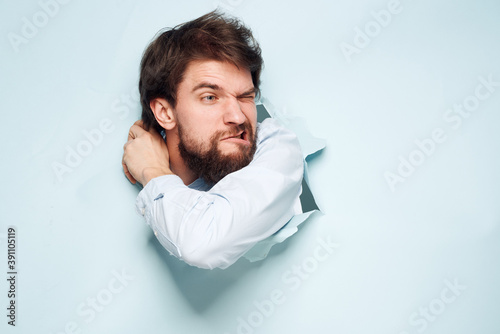 Emotional man peeks out from behind the wall of a career office work official